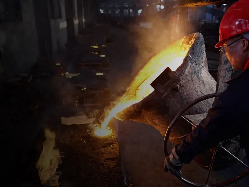 Molten metal pouring from a ladle in a steel foundry