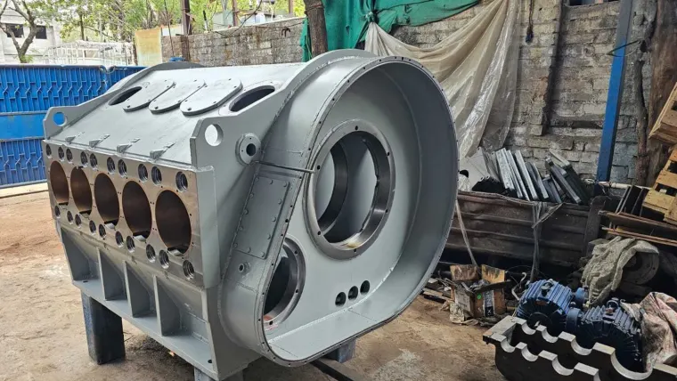 The fabricated housing seen from the opposite side, with the five-bore machined face, top cover plates and curved end plate