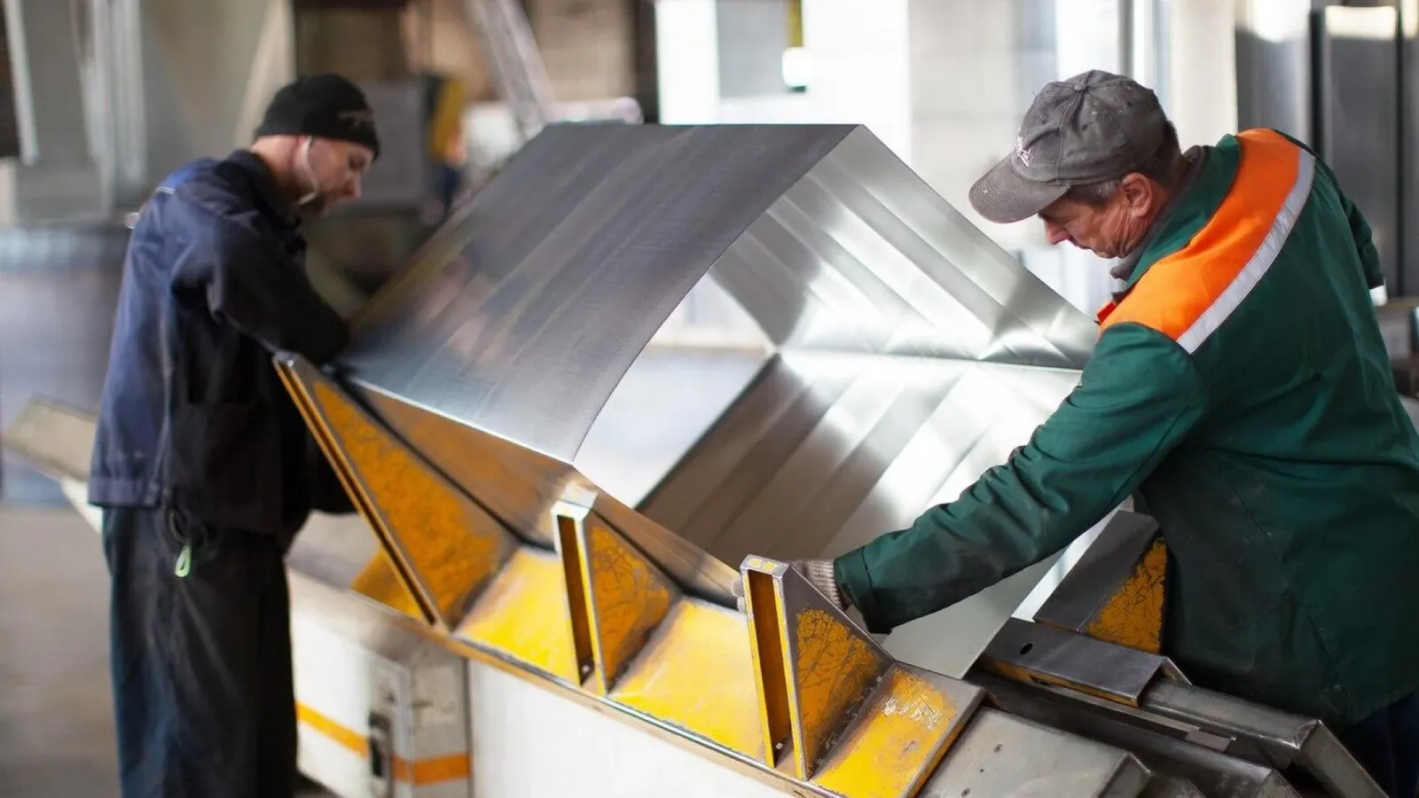 Fabricator welding a custom metal component in an Anaya Enterprises fabrication workshop